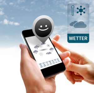 Hands holding smartphone with weather widget